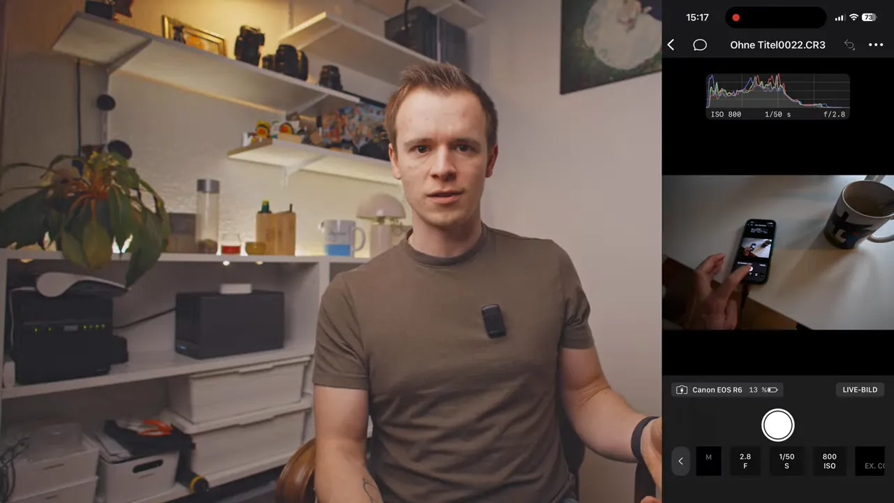 Person sitzt am Schreibtisch, rechts Smartphone-Display zeigt Capture One Remote mit Histogramm, Vorschaubild und Kameraeinstellungen.