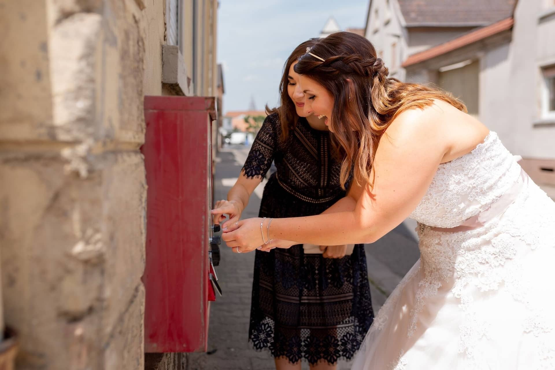 Standesamtliche Trauung Mutterstadt Altes Rathaus Bad Duerkheim Schlossgarten IMG 2527.DJC1Bj 6 Braut und Freundin posieren lachend an rotem Briefkasten in der Fußgängerzone Mutterstadt
