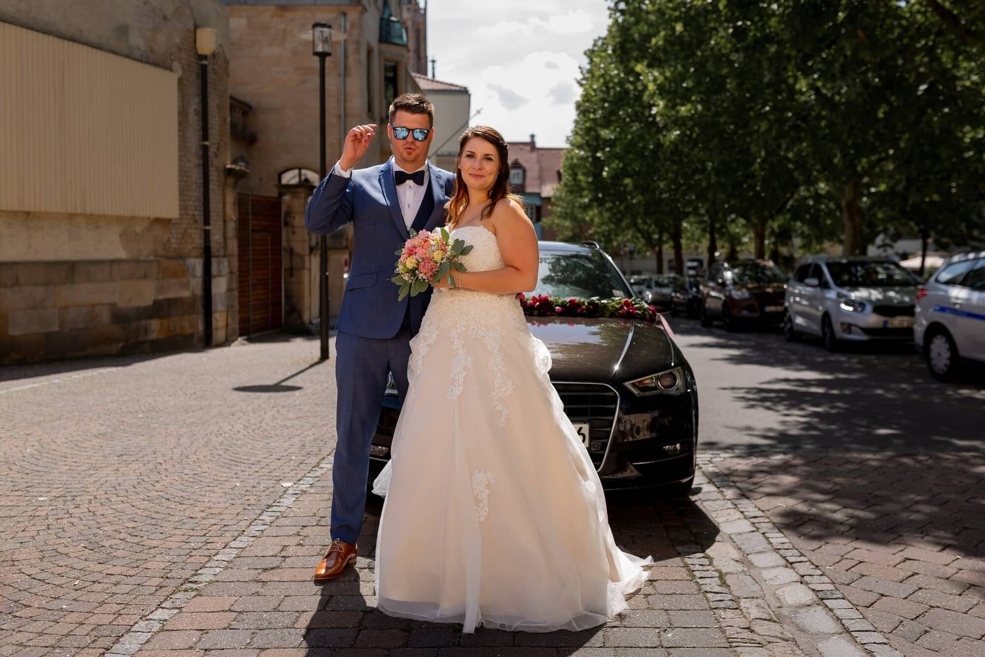 Standesamtliche Trauung Mutterstadt Altes Rathaus Bad Duerkheim Schlossgarten IMG 3327.C1tcw6m5 Brautpaar vor schwarzem Oldtimer auf gepflasterter Straße nach der Trauung in Mutterstadt