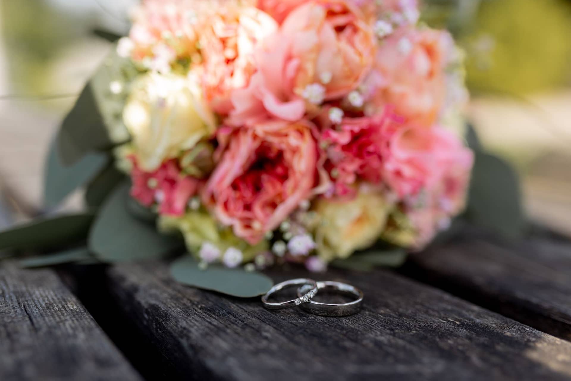 Standesamtliche Trauung Mutterstadt Altes Rathaus Bad Duerkheim Schlossgarten IMG 3882.BAlJi4uI Eheringe auf alter Holzbank mit roten Rosenblüten beim Brautpaarshooting Bad Dürkheim