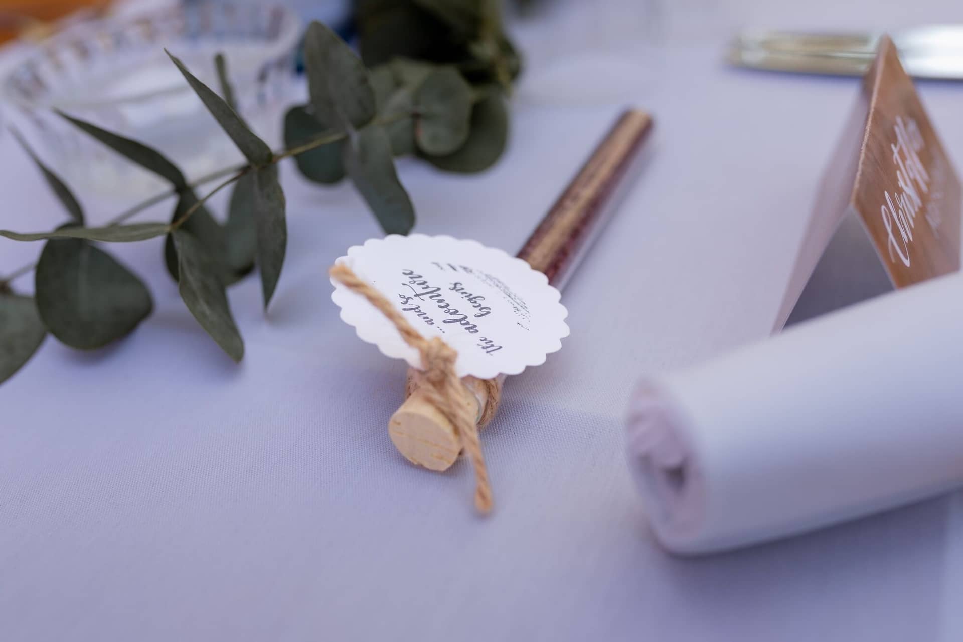 Standesamtliche Trauung Mutterstadt Altes Rathaus Bad Duerkheim Schlossgarten IMG 4079.7npTyUe8 Herzförmiges Gästebuch mit Holzrahmen und Schafgarben auf weißer Tischdecke bei der Hochzeitsfeier