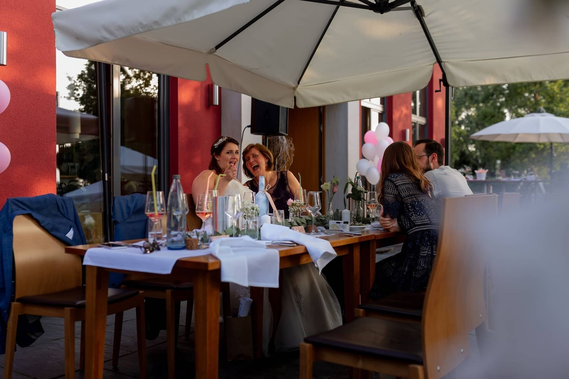 Standesamtliche Trauung Mutterstadt Altes Rathaus Bad Duerkheim Schlossgarten IMG 4522.CeCh1EVP Hochzeitsgesellschaft am Tisch im Freien mit Rosengestecken, pinken Luftballons und weißen Tischdecken
