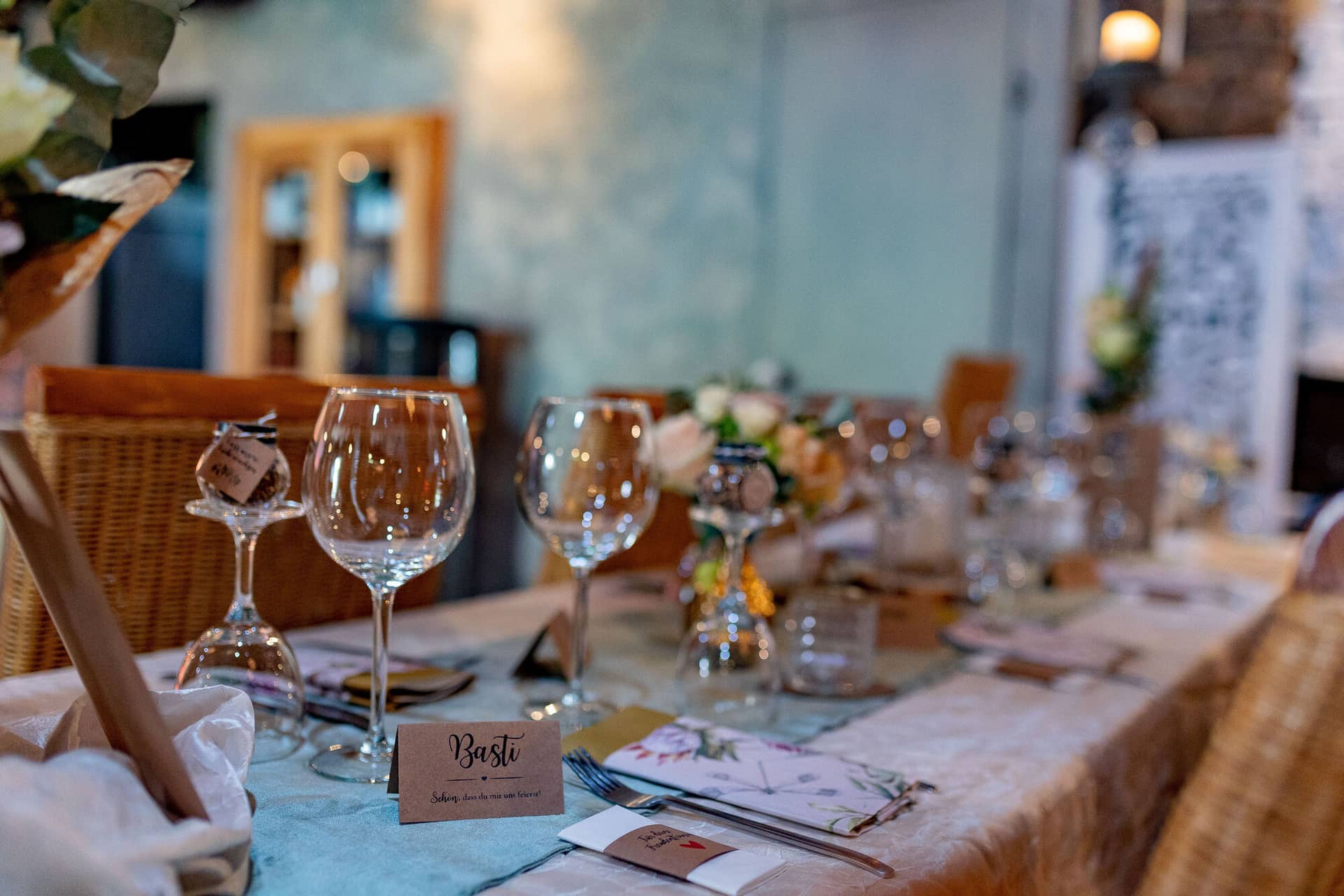Verena Marius Hochzeitsfotograf Fotograf Worms Mettenheim 12.DR0Uv6p2 Gedeckter Tisch im Dach der Welten mit Champagnergläsern, Blumenarrangement und persönlichen Tischkarten in modernem Industrieambiente
