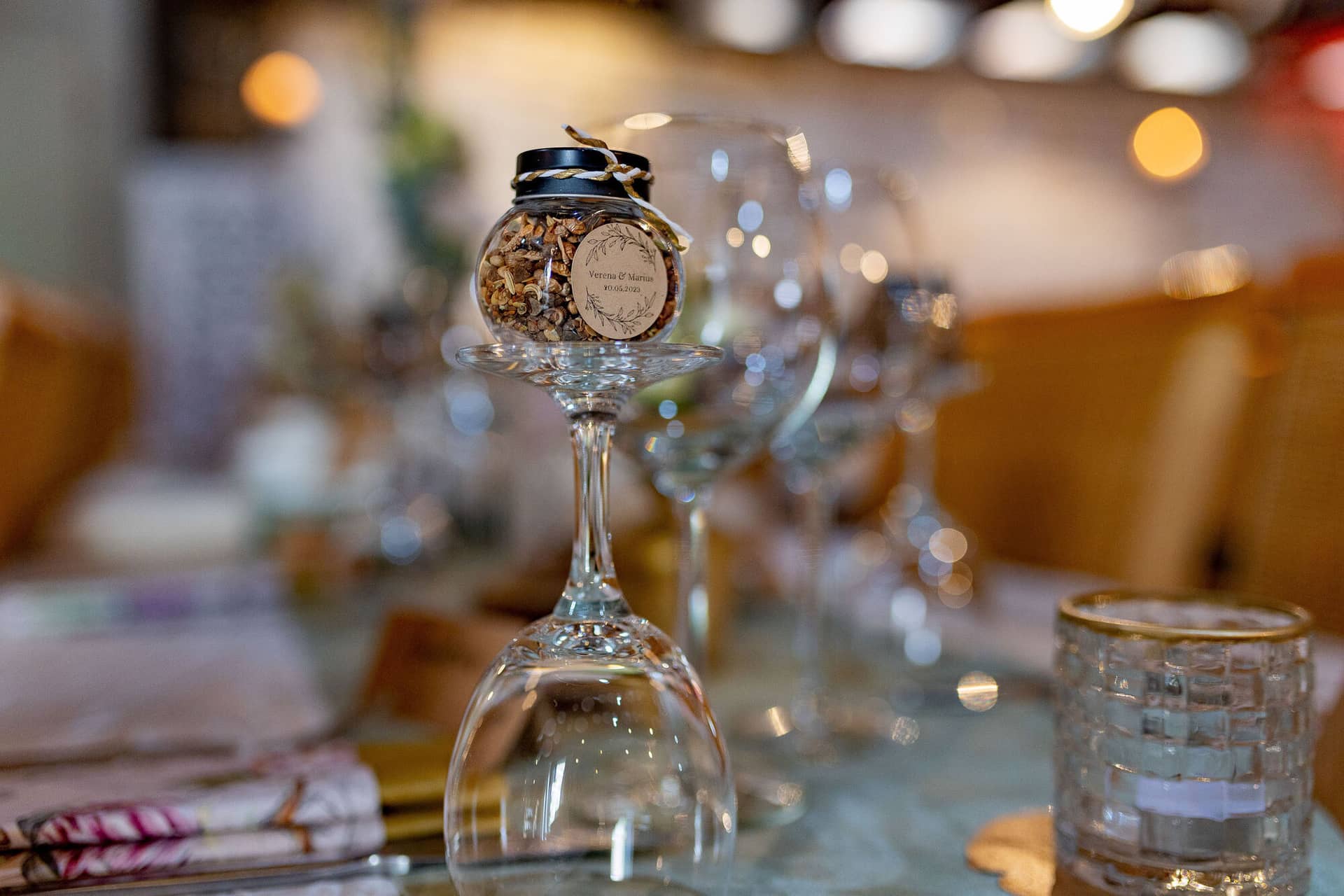Verena Marius Hochzeitsfotograf Fotograf Worms Mettenheim 14.B1KDTh7y Detailaufnahme der personalisierten Hochzeitsdekoration mit Gastgeschenk in einer Glasvase